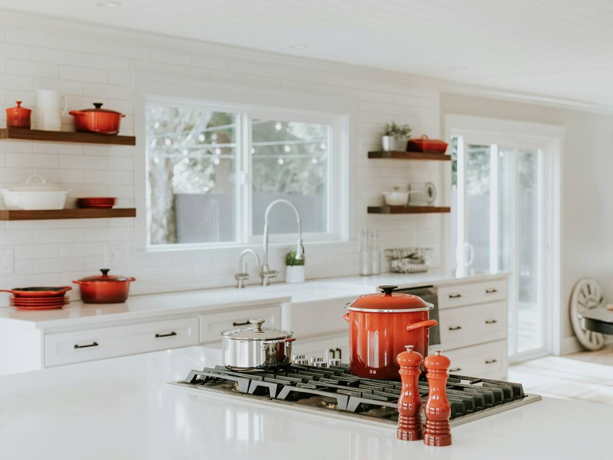 Bright white kitchen with a gas cooktop and cookware